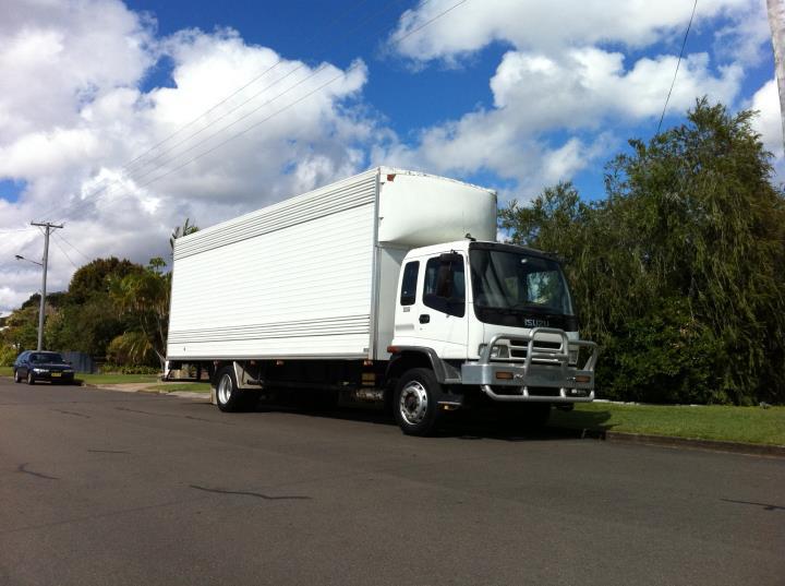 White pantech removals truck parked on a street under a blue sky