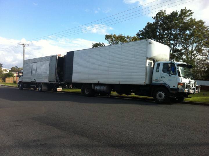 Removals truck and furniture trailer parked together on a suburban street
