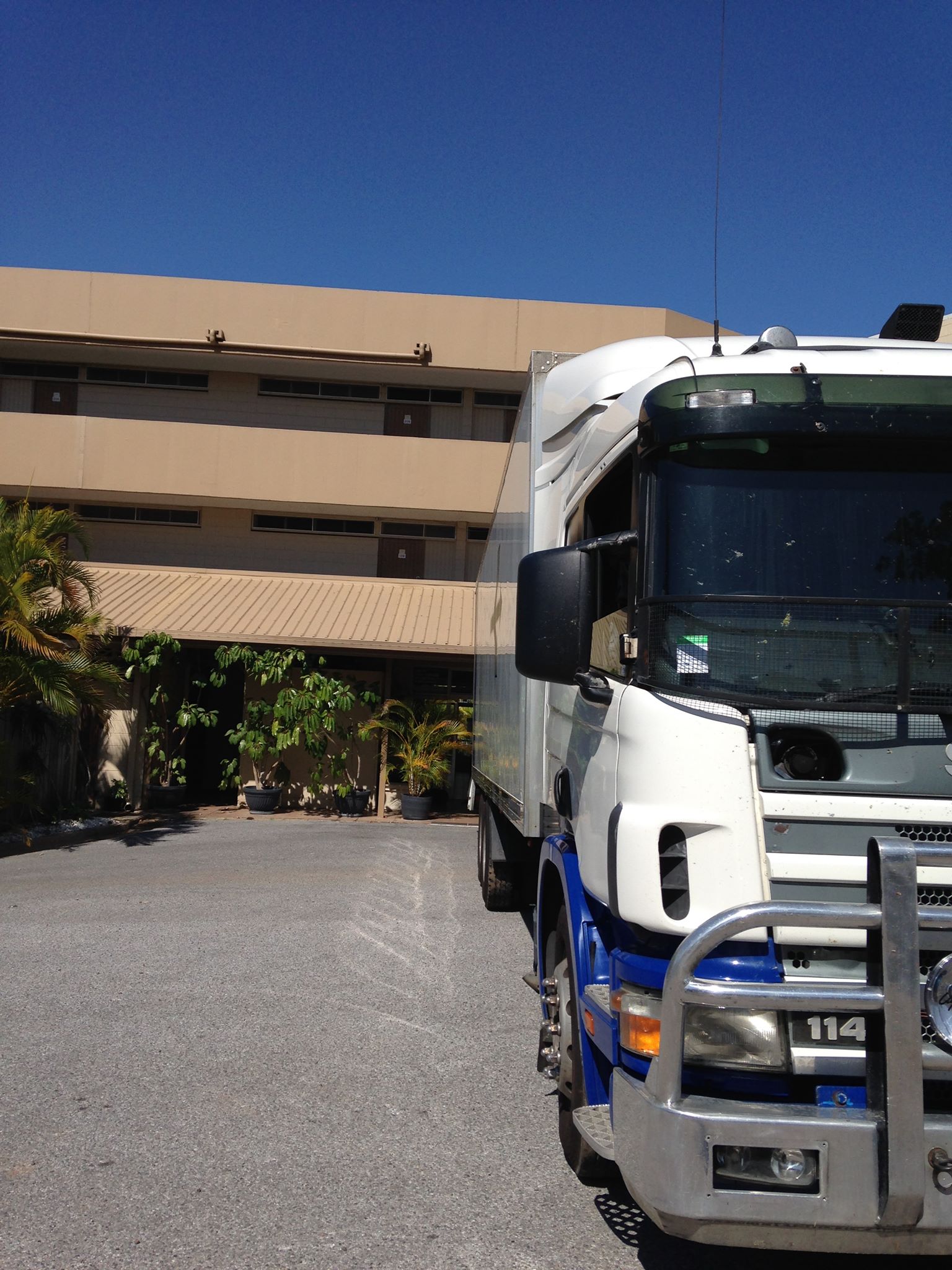 Front of a removals truck parked outside a multi-storey building
