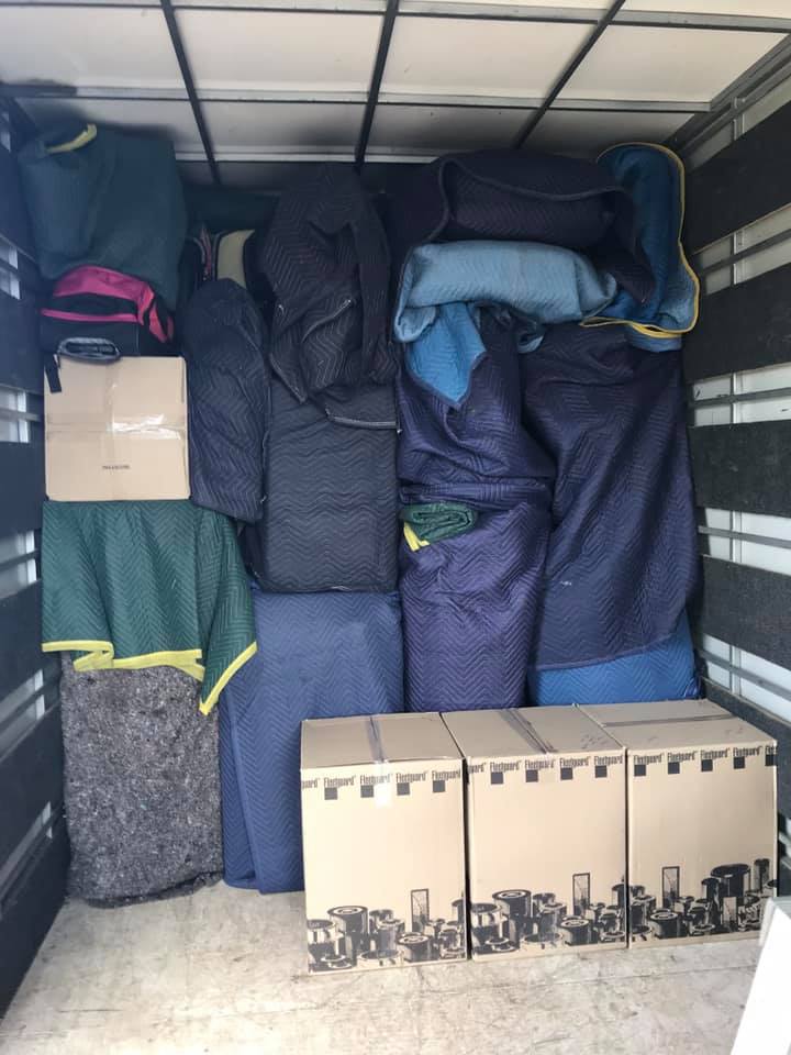 Removals truck packed with blanket-wrapped furniture and cartons