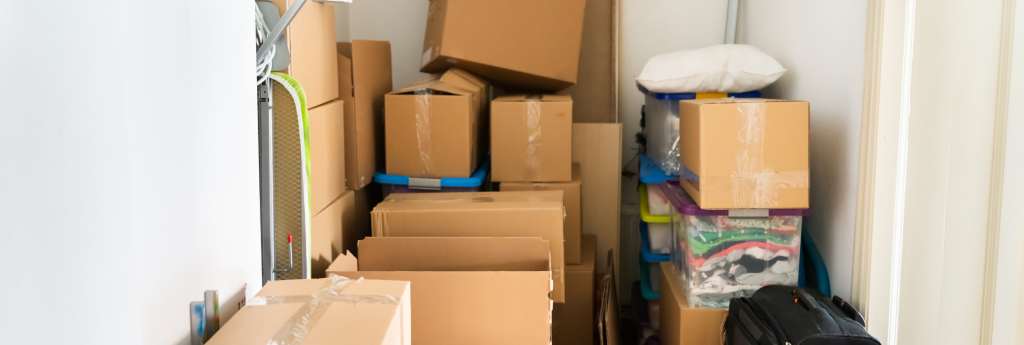 Moving boxes and household items stacked inside a storage room