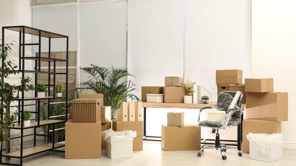 Office with packed boxes, a plastic-wrapped chair and shelving ready for a move